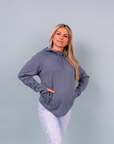 Expecting active mother wearing light blue hooded sweatshirt