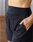 Mid to high waist supportive postpartum swift running shorts with pockets in black