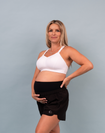 Front view of pregnant mother wearing a white supportive breastfeeding bra