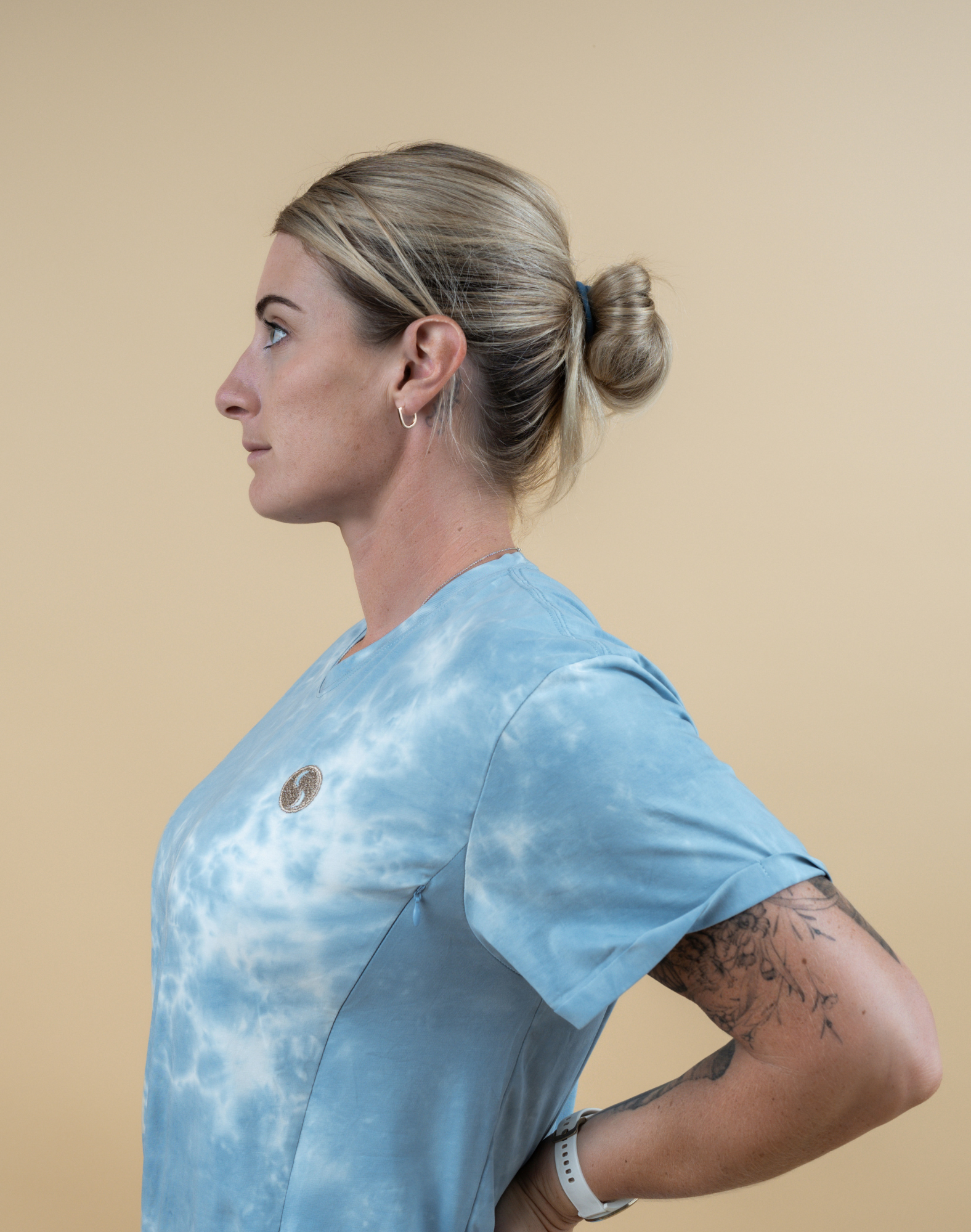 Side view, of happy, fit mum wearing blue and white tie-due breastfeeding t-shirt