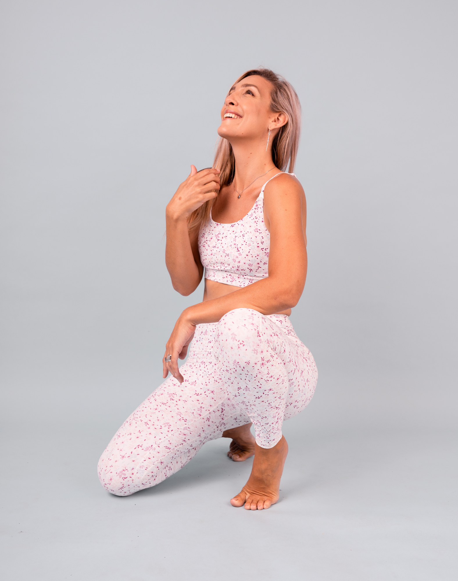 Happy fit mum kneeling down in the nursing bra and matching 7/8 postpartum leggings