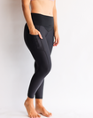 Back view of black high waisted maternity leggings with pockets in 7/8 length