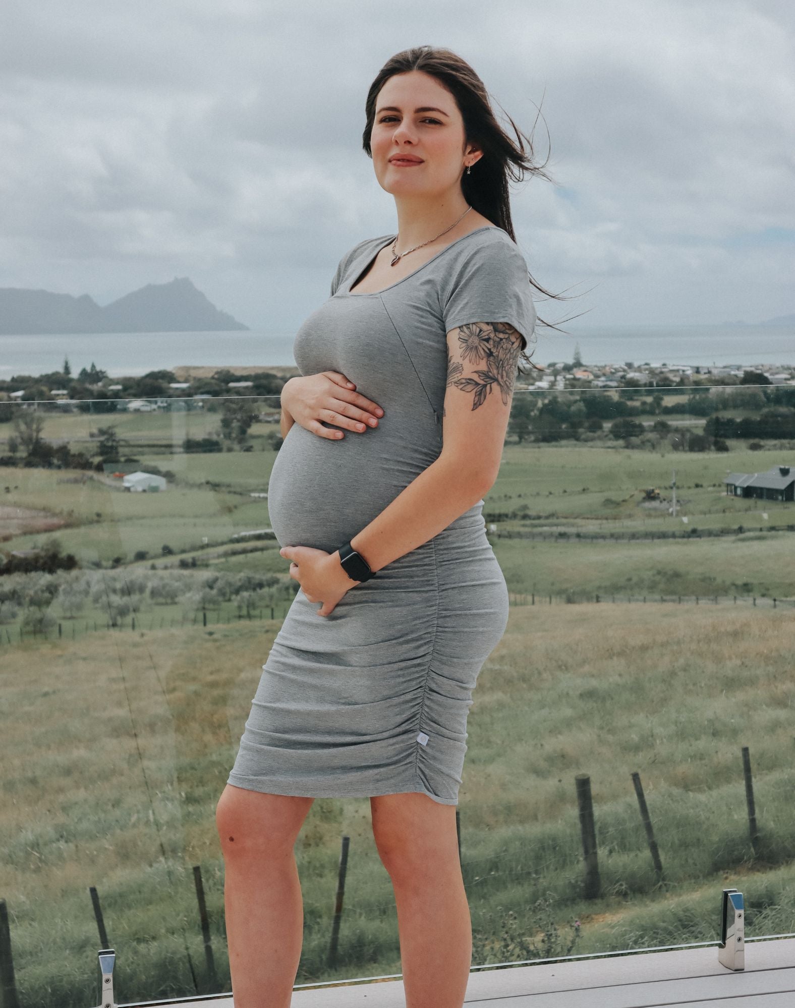 Side view of pregnant mother wearing black maternity short sleeve dress
