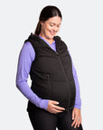 Happy mother wearing a black women's puffer vest over her maternity clothing