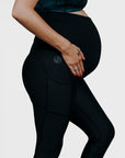 Side view of pregnant mother wearing black maternity leggings