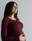 Pregnant mother showing the nursing function of a burgandy long sleeve top